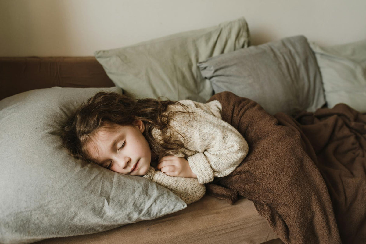 Toddler sleeping peacefully under a soft blanket