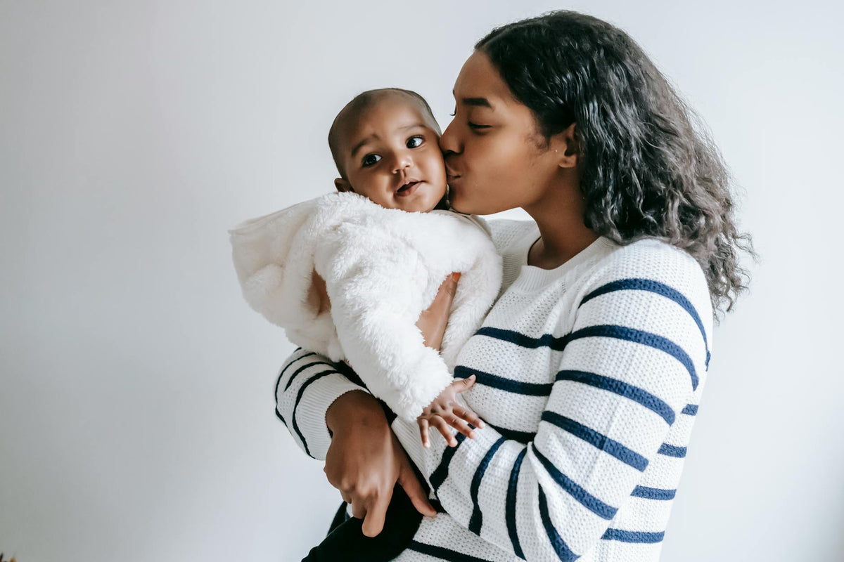 Mother gently kissing her baby